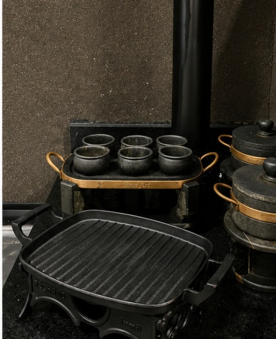 Detalhes em pedra-sabão e grelha de ferro fundido no espaço gourmet